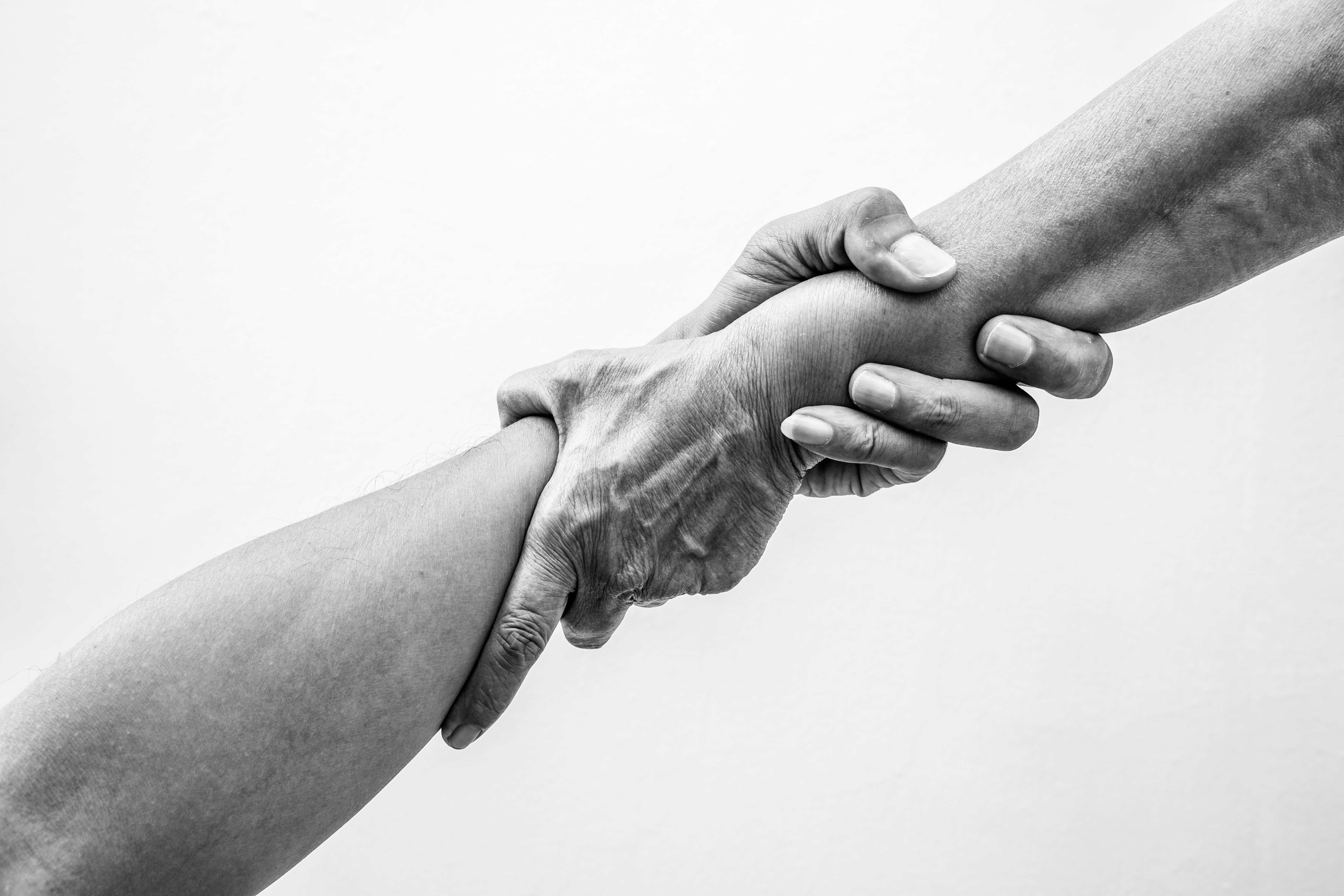 Help hands holding together in monochrome color representing friendship, partnership, help and hope, donation, assistance.