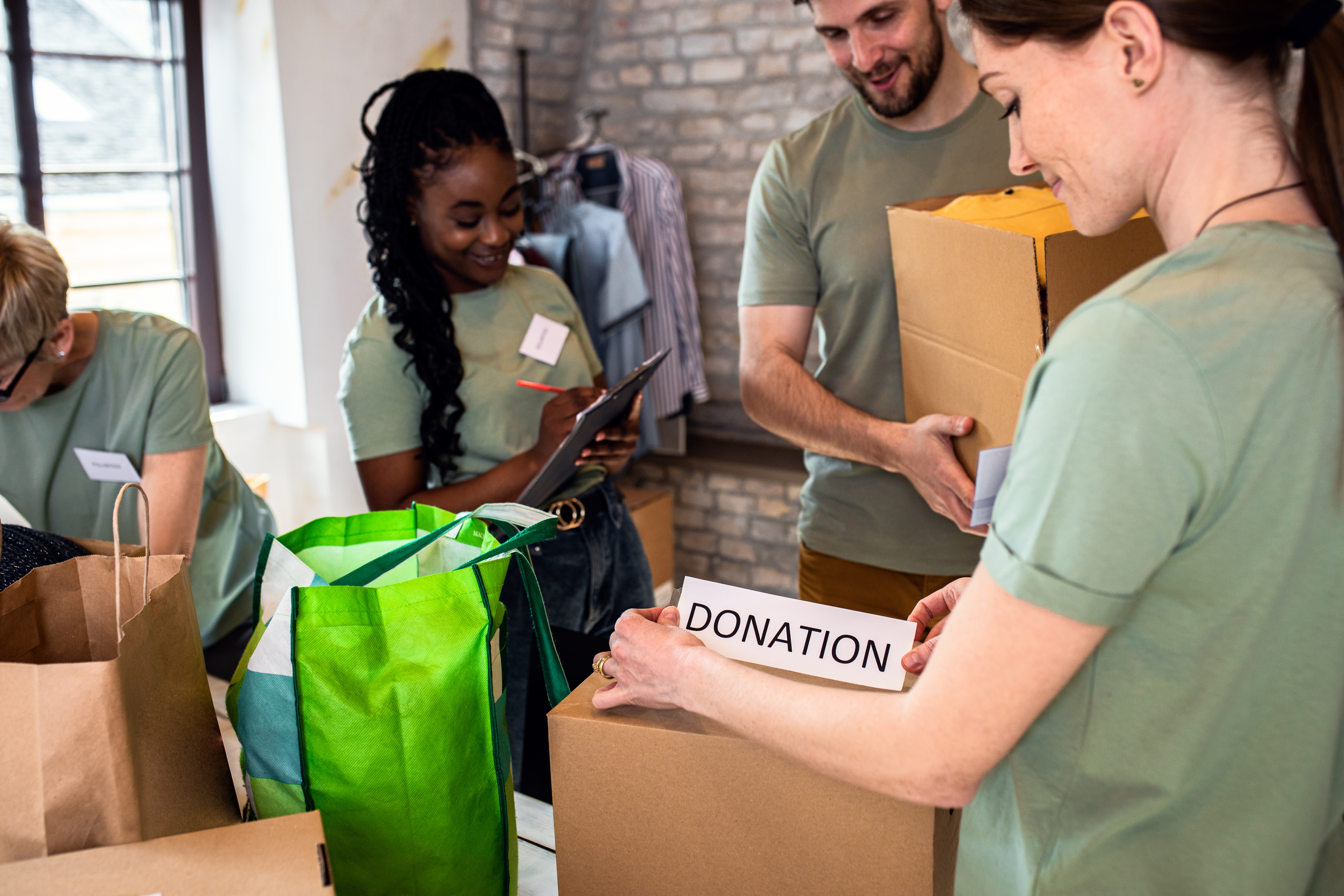 Group of volunteers with working in community charity donation center.